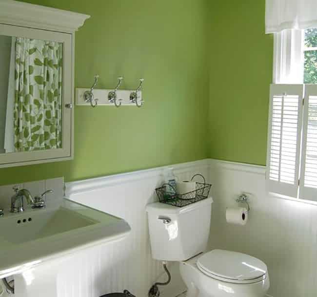 Green bathroom with pedestal sink and towel hooks