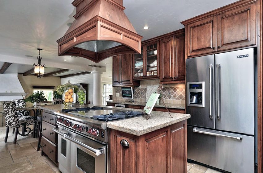 Kitchen with doors with raised panels and island with gas range