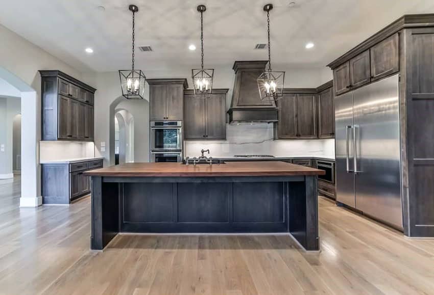 Craftsman style kitchen with dark stained cabinets and large butcher block island