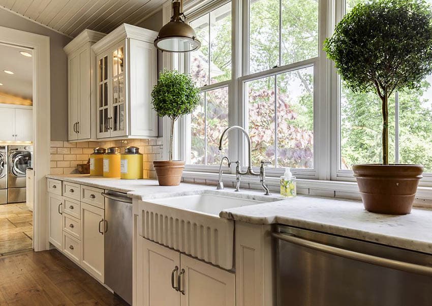 Farmhouse kitchen with fluted apron sink white cabinets with metal pull hardware