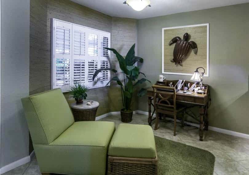 Home office with neutral green paint color and green side chair