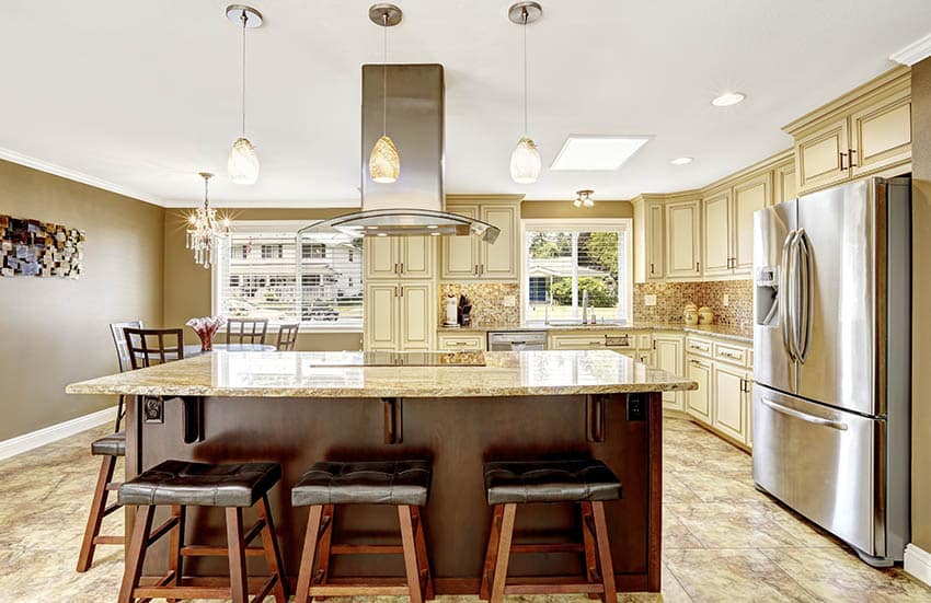 Kitchen with cream glazed kitchen cabinets and contrasting dark wood island