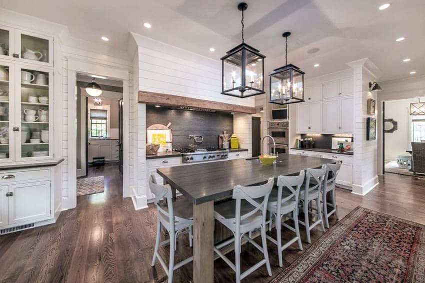 Modern farmhouse kitchen with shiplap walls, white cabinets and large table island