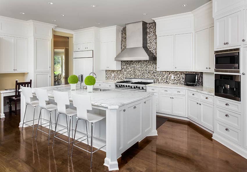 Luxury traditional kitchen with white shaker cabinets marble countertop large island and wood floors