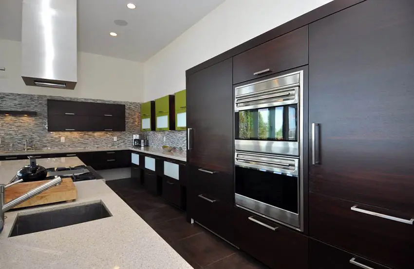 Kitchen with dark cabinets, granite backsplash and iced white countertops