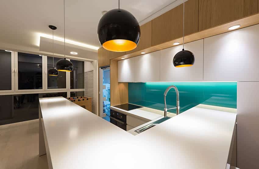Modern kitchen with green glass backsplash and white countertops