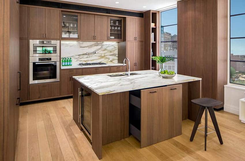 Kitchen with stained white oak cabinets, marble backsplash and wood slab floors