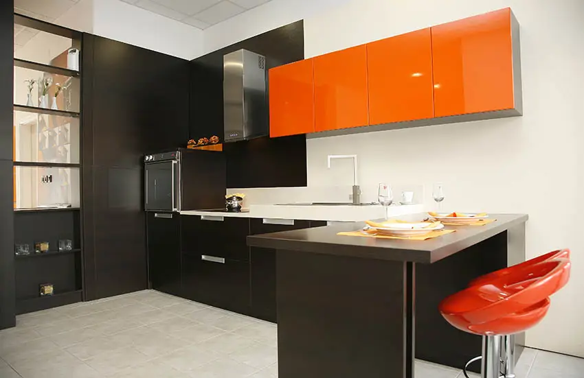 Orange and black modern kitchen with peninsula and bar stools