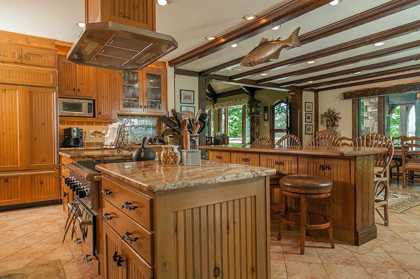 Rustic kitchen with beaded panel cabinets and two islands with beige granite countertops