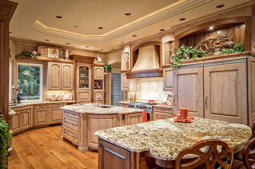 Kitchen with knotty cabinets, custom oven hood and beige granite 