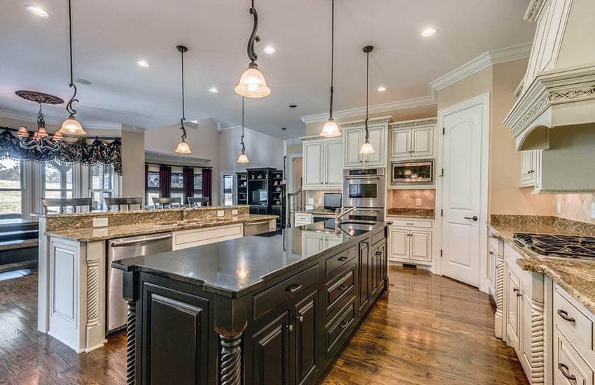 Traditional kitchen with antique white raised panel cabinets and black and beige granite countertops