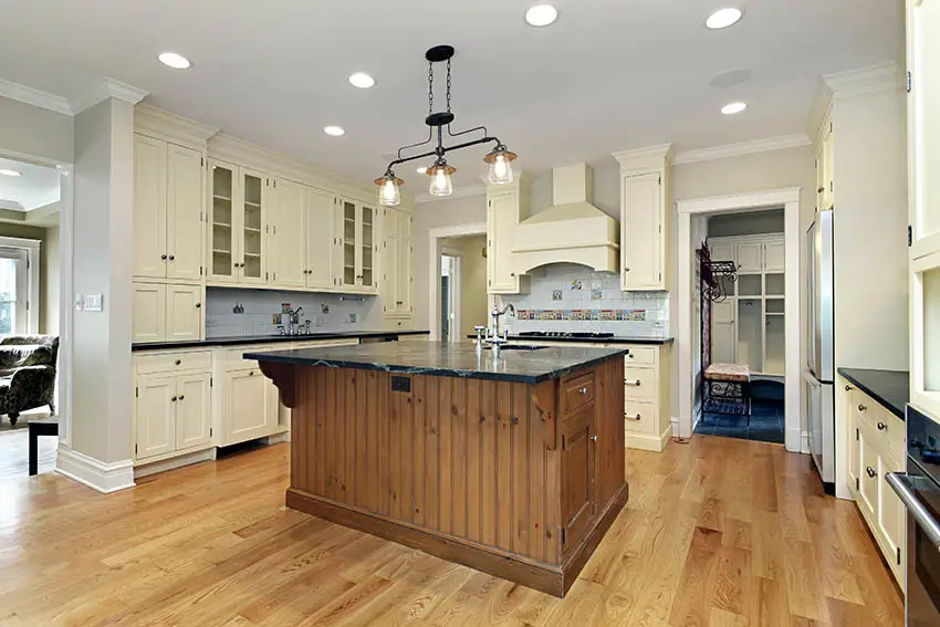 Traditional kitchen with glass mullion cabinet doors and cream color with dark wood island
