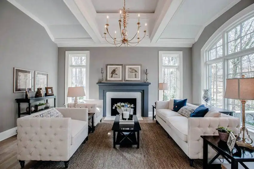 Living room with white furniture, gray painted fireplace and chandelier