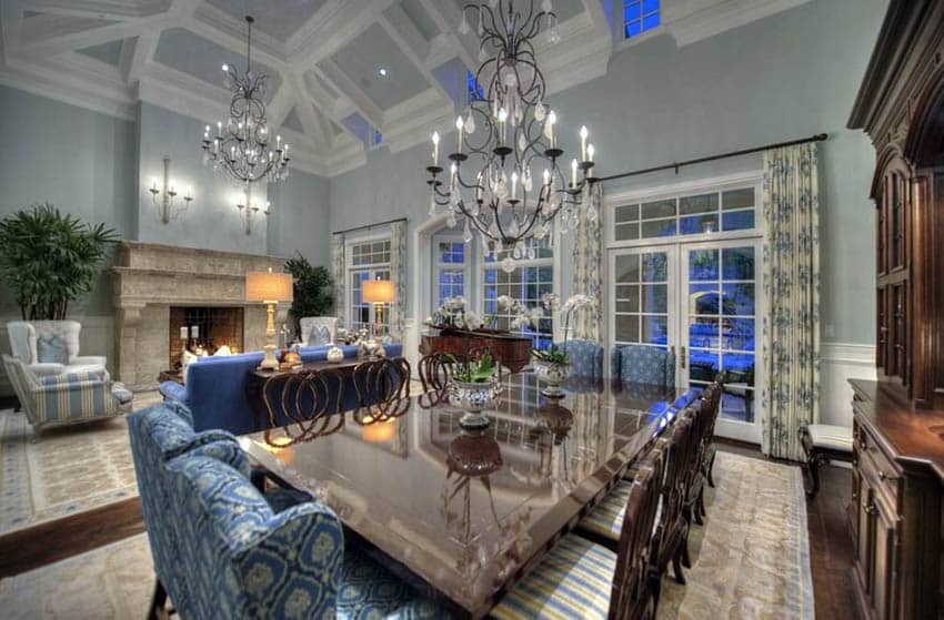 Blue green dining room with high ceilings and chandeliers