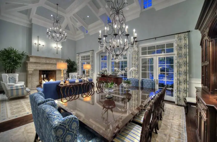 Blue green dining room with high ceilings and chandeliers