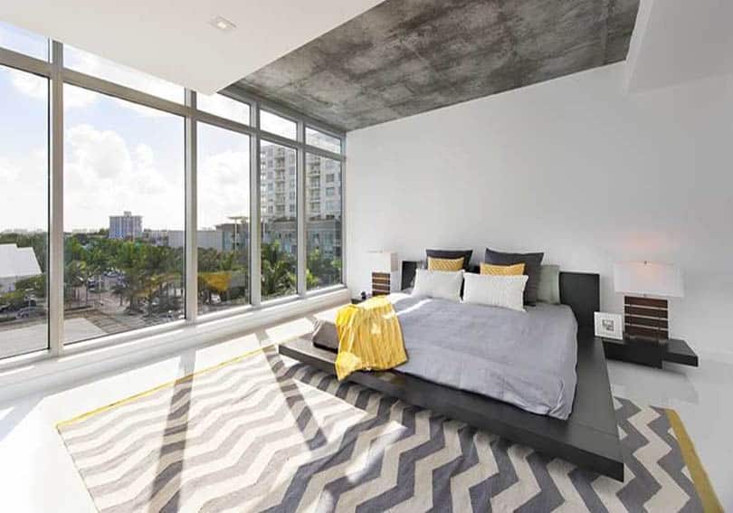 Gray bedroom with yellow accent decor pattern rug and window views