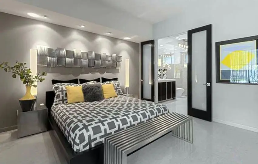 Gray modern master bedroom with metal ottoman and yellow decor