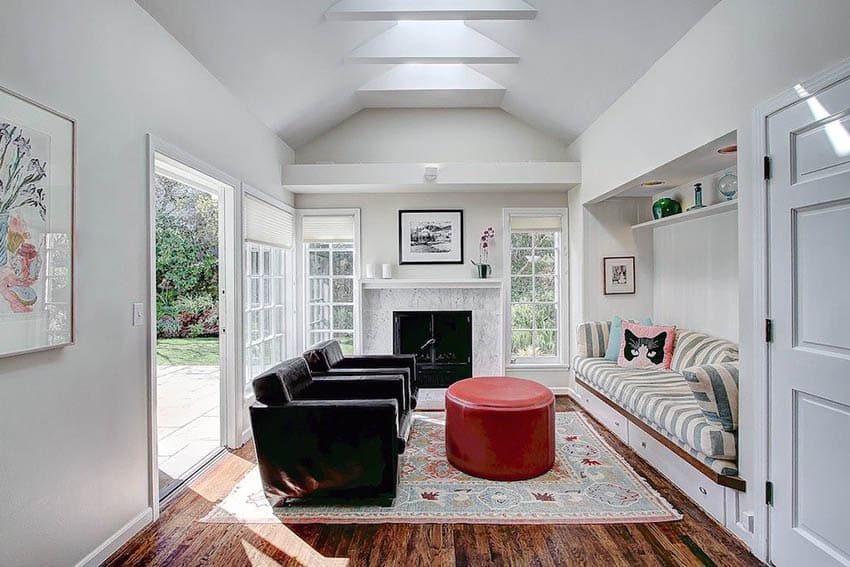 Room with built in seat , wood floors and red upholstered table