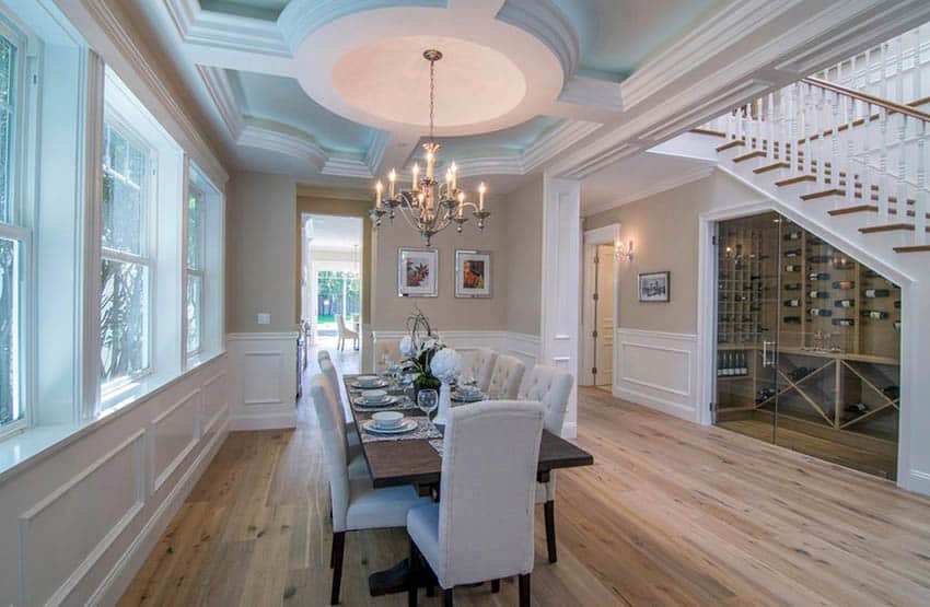 Traditional dining room with chandelier, beige paint and white wainscoting