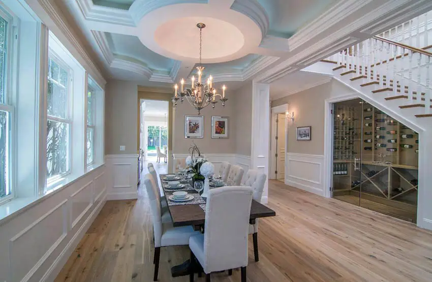 Dining room with decorative coffered design with reverse tray ceiling and chandelier