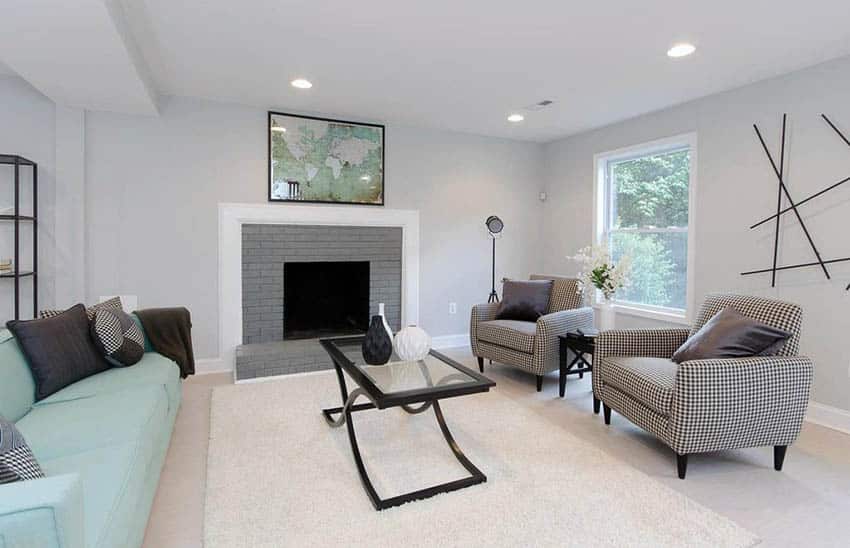 Room with gray painted accent fireplace with recessed lighting and uphosltered chairs