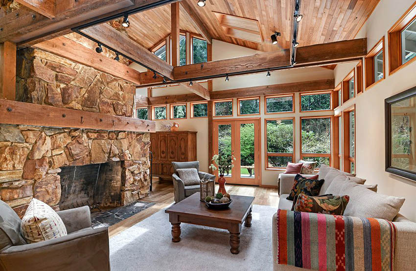 Country style living room with rock fireplace, arched ceiling and large wood beams