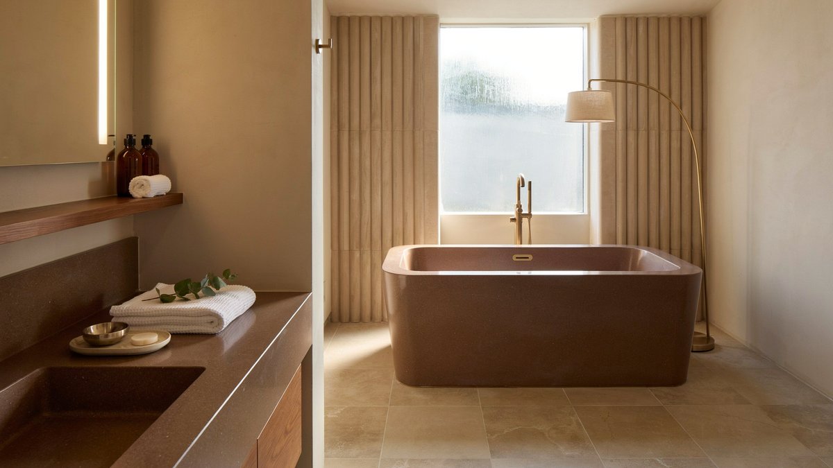 Columned bathroom framing an oversized jetted tub with brown granite surround