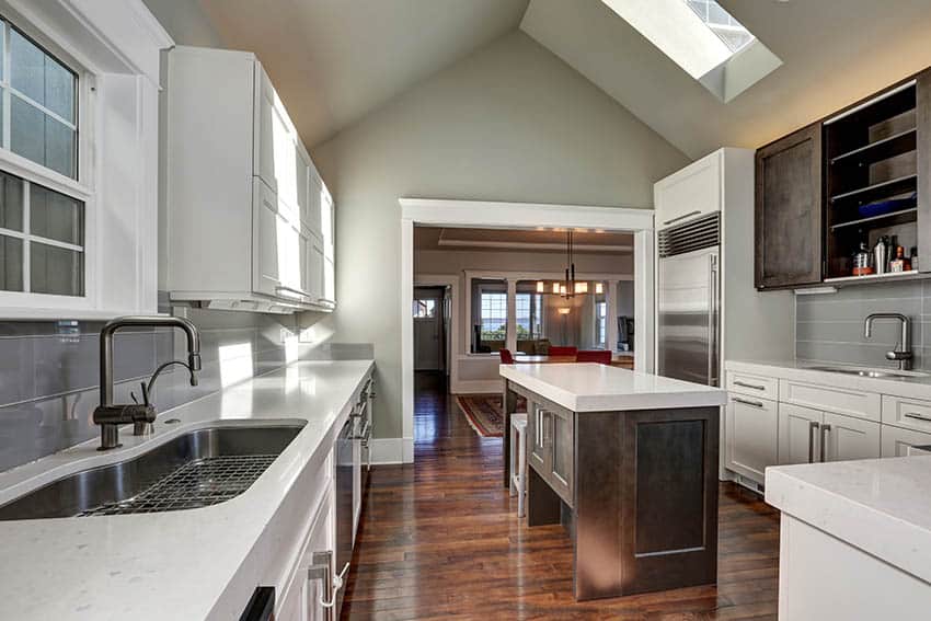 Kitchen with vaulted ceiling greige paint color and white cabinets with quartz countertops