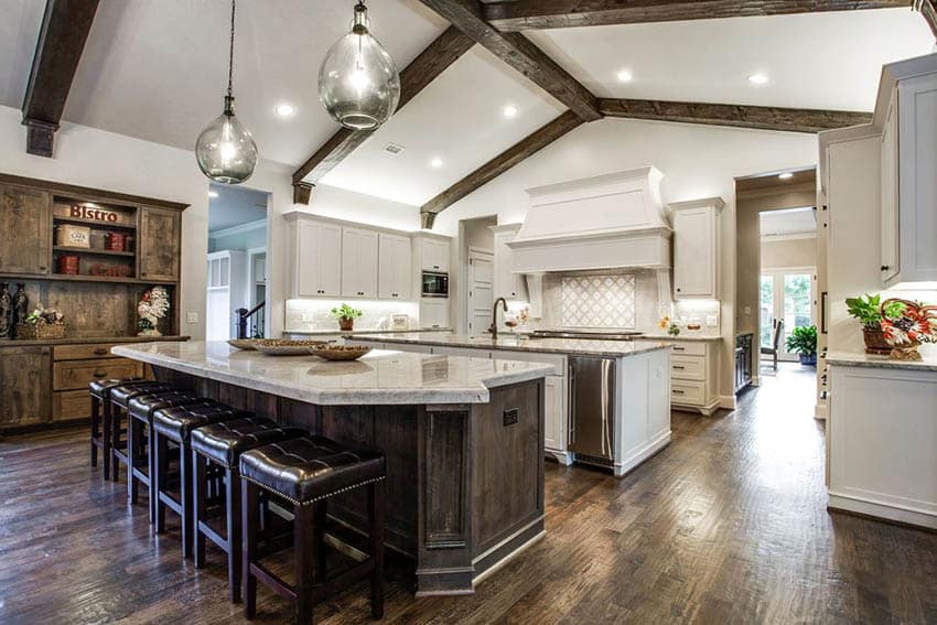 White shaker cabinets and dark wood flooring with six seats made of leather