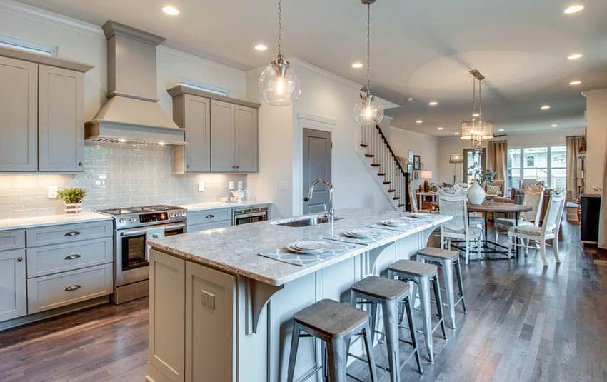 Open concept kitchen with white paint gray cabinets and gray marble counter