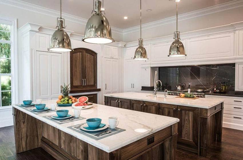 Luxury kitchen with open plan design, two islands, marble countertops, white cabinets and chrome pendant lights
