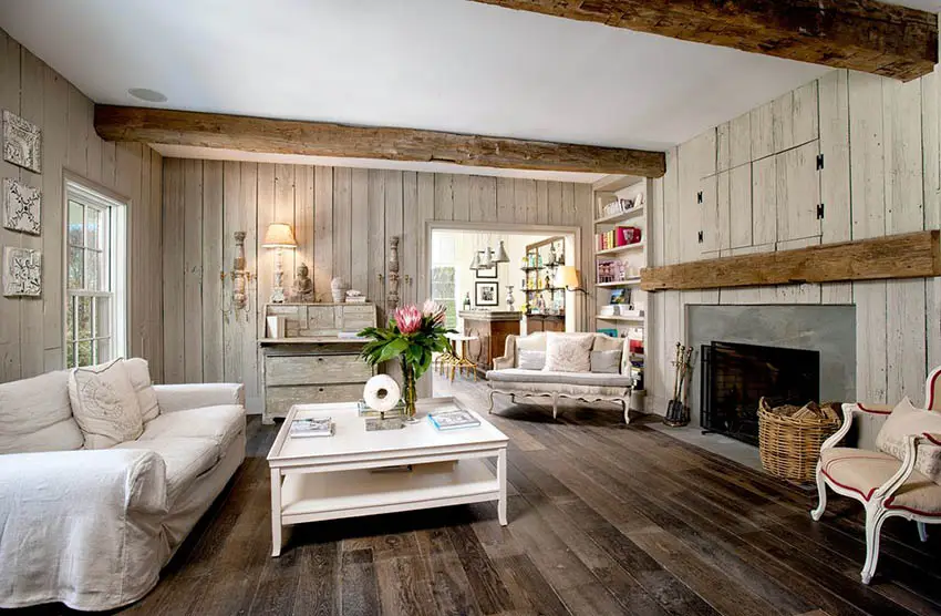 Rustic farmhouse living room with wood panel walls, reclaimed wood beams and hardwood floor