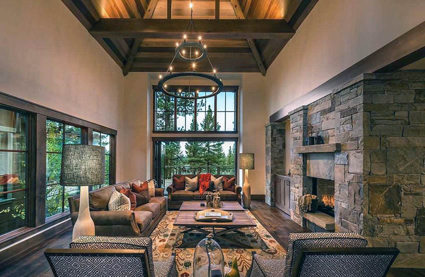 Rustic living room with high ceiling stone fireplace and wood flooring