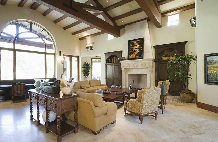 Rustic living room with vaulted ceiling, arched window and stone fireplace