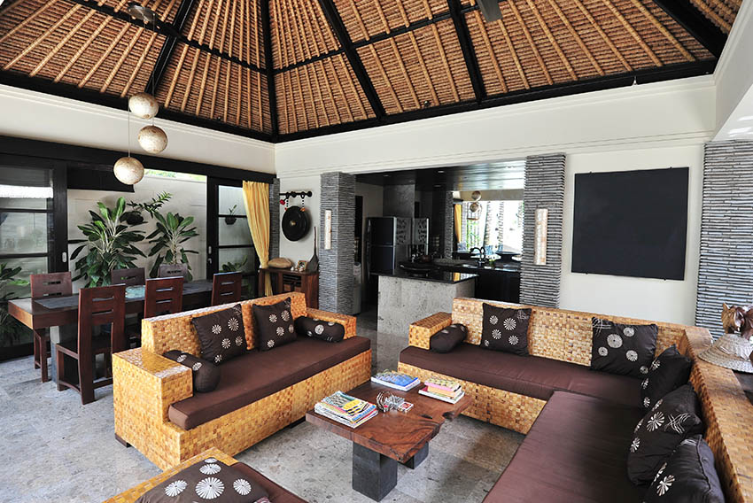 Rustic tropical themed living room with bamboo ceiling and open kitchen