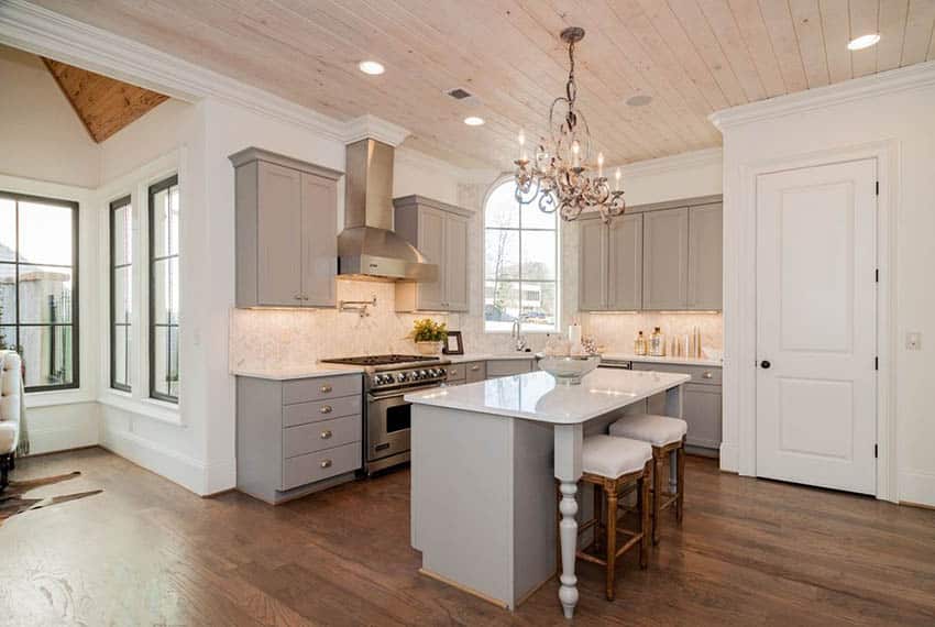 Kitchen with gray cabinets and white walls with bleached wood slat ceiling