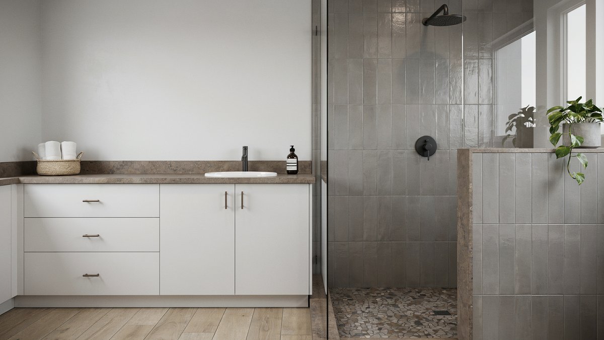 Gray and white bathroom with a glass shower and brown mosaic floor