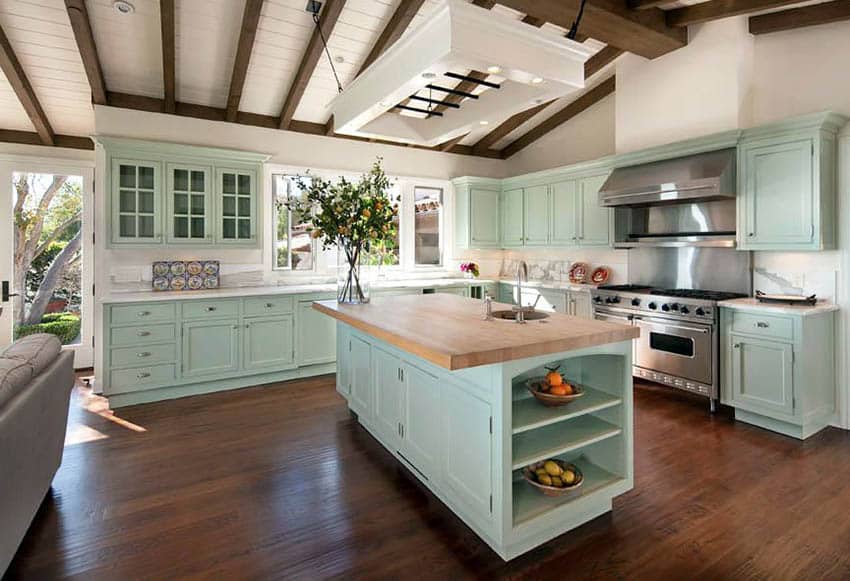 Traditional kitchen with mint green cabinets white countertops with butcher block island