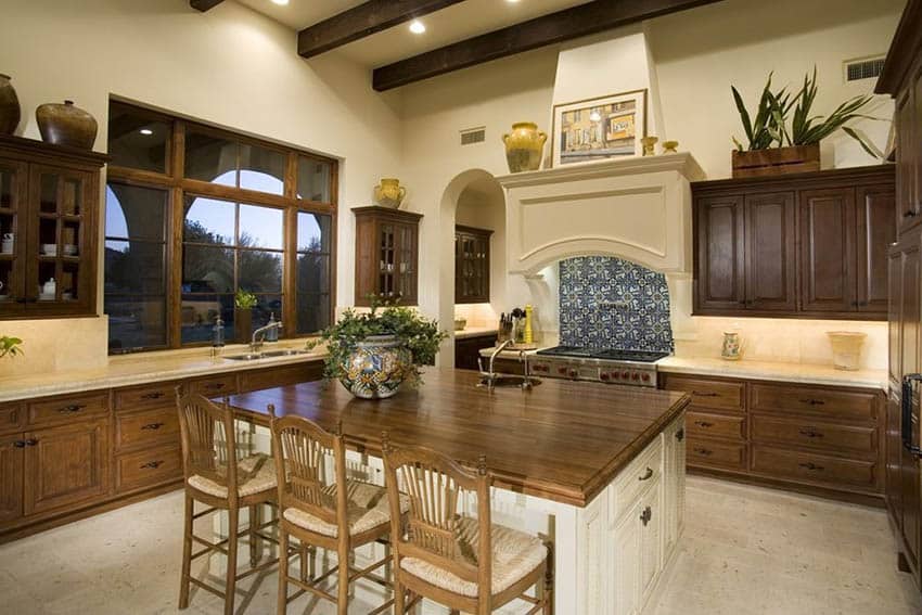 Traditional kitchen with stained wood raised cabinets, cream yellow painted walls and butcher block dining island