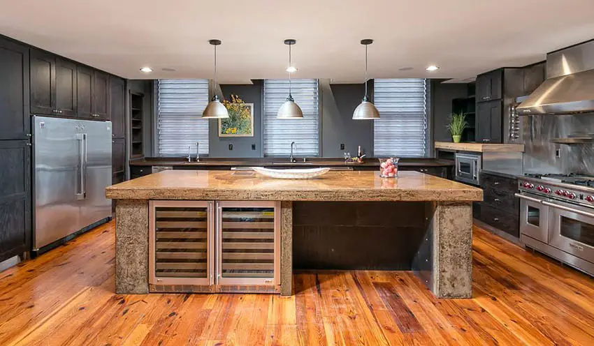 Kitchen with natural stone island with louvered cabinets and windows with blinds
