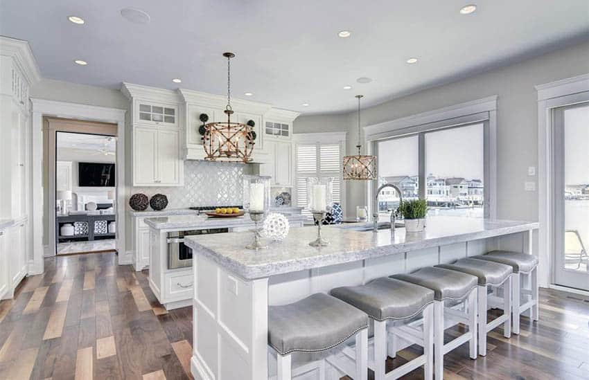 Kitchen with double islands, white cabinetry and walnut hardwood flooring