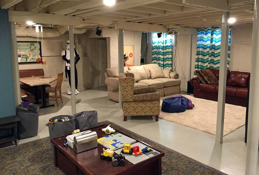 Basement with coffered ceiling design, couches and painted floors