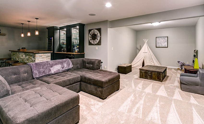 Basement with home bar and beige carpet