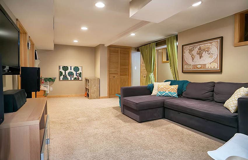 Basement with olive green custains, wall art and recessed lighting