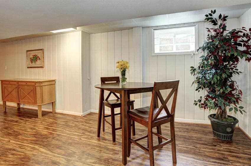 Basement with laminate wood flooring, white walls and dining set for two