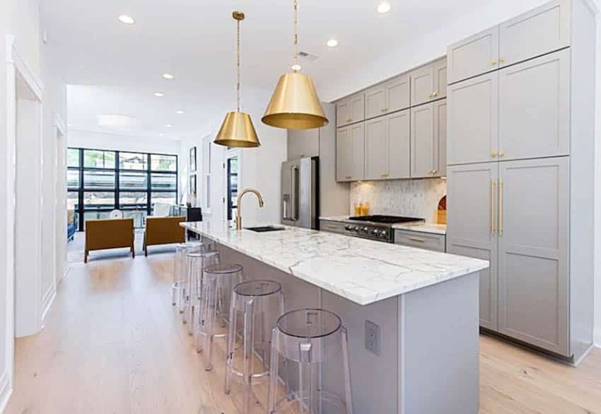 Contemporary style kitchen with gray cabinets, gold hardware and marble surface island