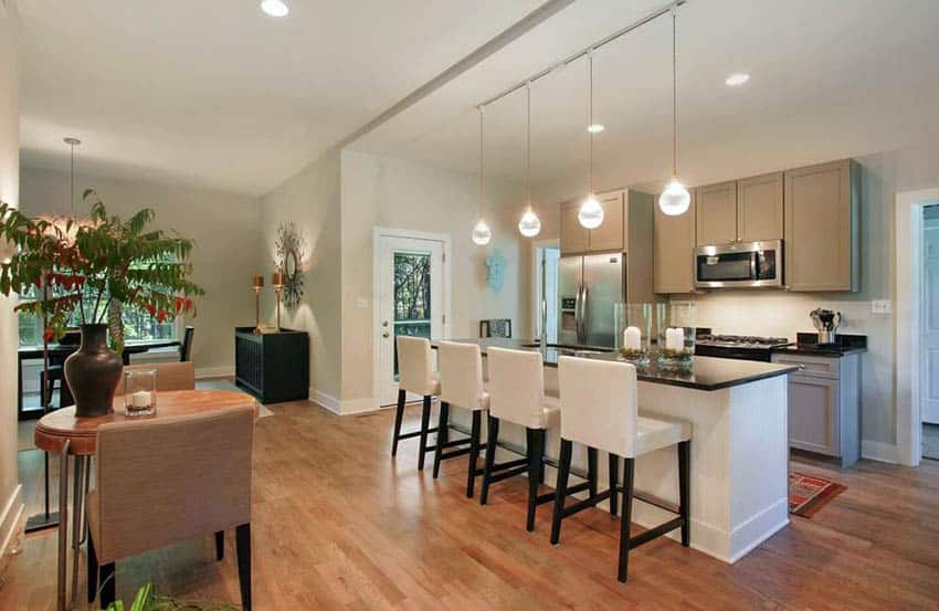 Contemporary open plan kitchen with maple wood floors and two tone cabinets