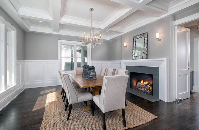 Dining room with silver chandelier, white wainscoting, dark wood floors and gray painted walls