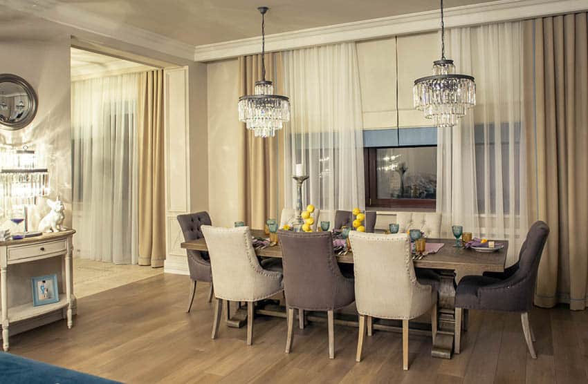 Dining room with two crystal chandeliers and matching table lamp and mirror