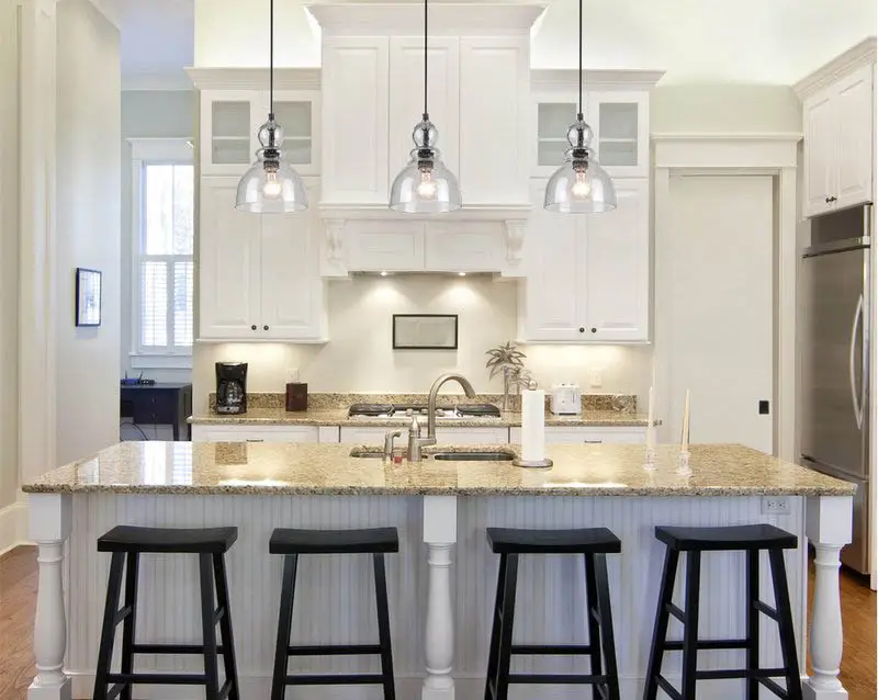 Breakfdast bar with granite top, black stools and down light style pendants